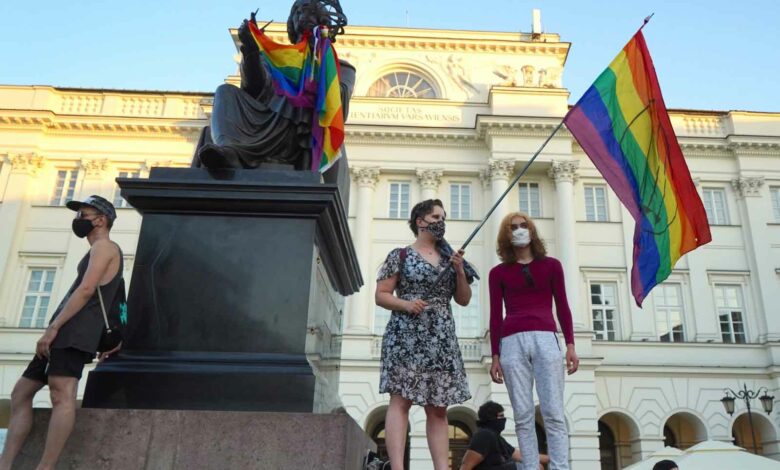 Ein LGBT-Aktivist mit einer Regenbogenfahne steht am 7. August 2020 auf dem Kopernikus-Denkmal in Warschau, Polen. Die polnische Polizei verhaftete am Freitag einen Aktivisten für die Rechte von Homosexuellen im Zentrum von Warschau und setzte einen Gerichtsbeschluss für eine zweimonatige Sicherungsverwahrung um, der wütend wurde Szenen, als Dutzende protestierten. Die Aktivistin, die vor Gericht offiziell als Mikhail Sz bezeichnet wurde, sich aber als Frau mit dem Namen Margo identifiziert, wird verdächtigt, im Juni in Warschau einen Lieferwagen mit homophoben Parolen beschädigt zu haben. (Foto: JANEK SKARZYNSKI/AFP)