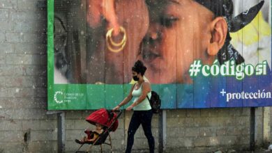 Eine Frau und ihr Baby gehen am 23. September 2022 in Havanna im Regen an einem Banner zugunsten des neuen Familienkodex-Referendums vorbei. Die Kubaner werden am Sonntag in einem Referendum darüber abstimmen, ob gleichgeschlechtliche Ehen und Leihmutterschaften zugelassen werden sollen Experten sagen, könnte sich in eine Gelegenheit verwandeln, Widerstand gegen die Regierung zu äußern. (Foto von YAMIL LAGE / AFP)