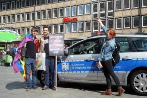 Der leicht identifizierbare BAfmW-Dienstwagen bei der Gegen-Demo für Alle. Im Hintergrund der Reisebus, mit dem die Vertreter des politischen Christentums unterwegs sind.(Foto: Bundesamt für magische Wesen)